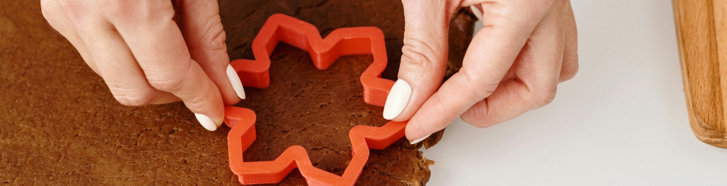 2 mains qui utilisent un emporte-pièce en forme d'étoile pour réaliser un biscuit