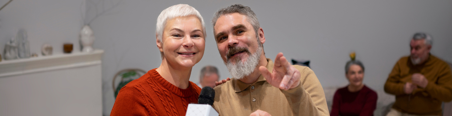 Une femme et un homme chantent au micro